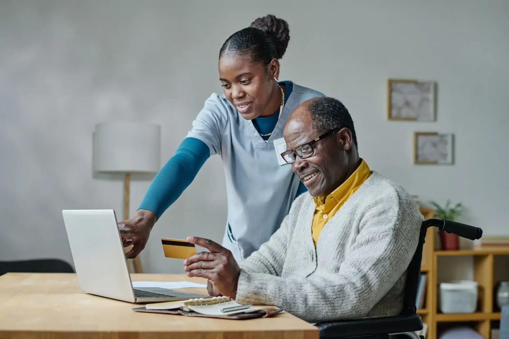Caregiver helping a patient with an online enrollment task